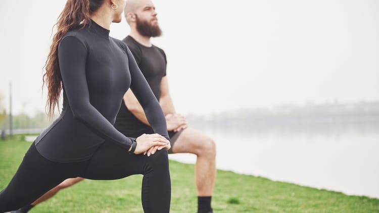A couple stretching outdoors demonstrating RV healthy living